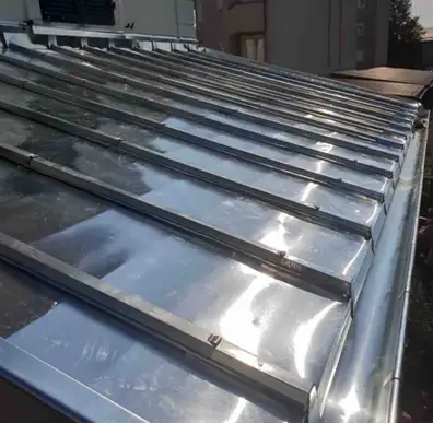 Travaux de zinguerie : façonnage d'une bande de rive en zinc